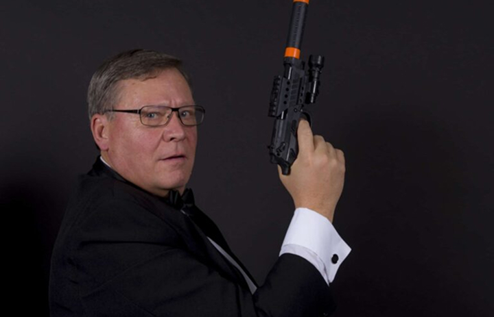 Un homme posant dans un photobooth sur le thème agent secret